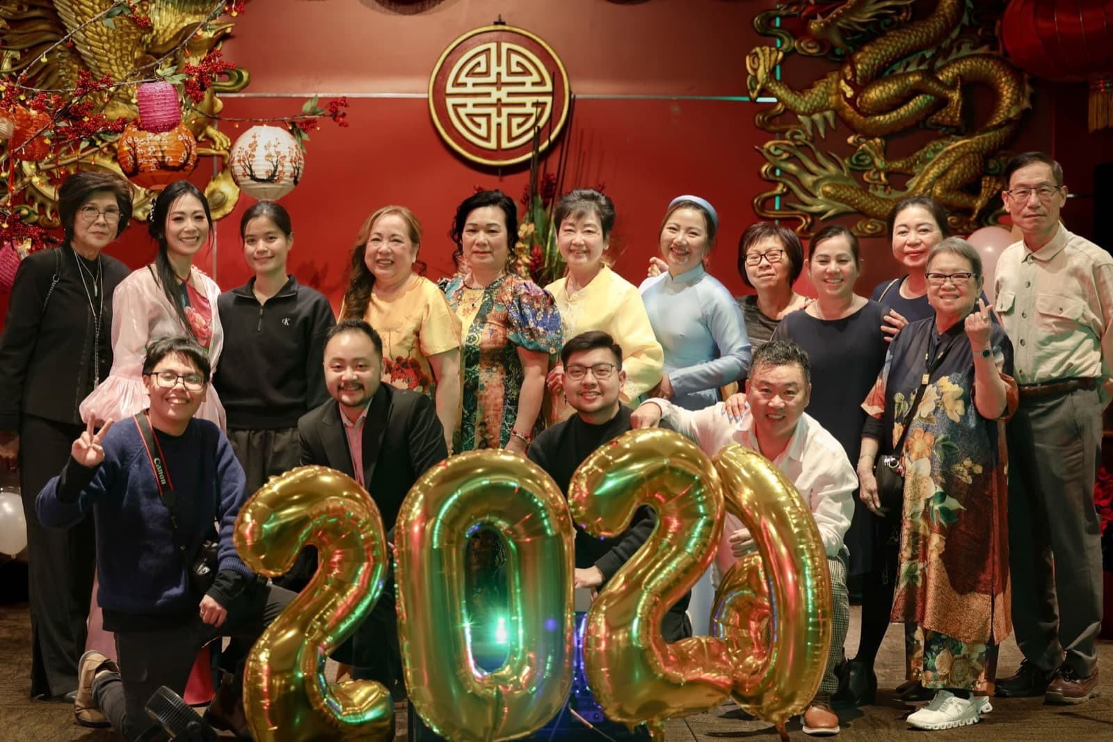 The group together behind gold number balloons at the Lunar New Year evening.